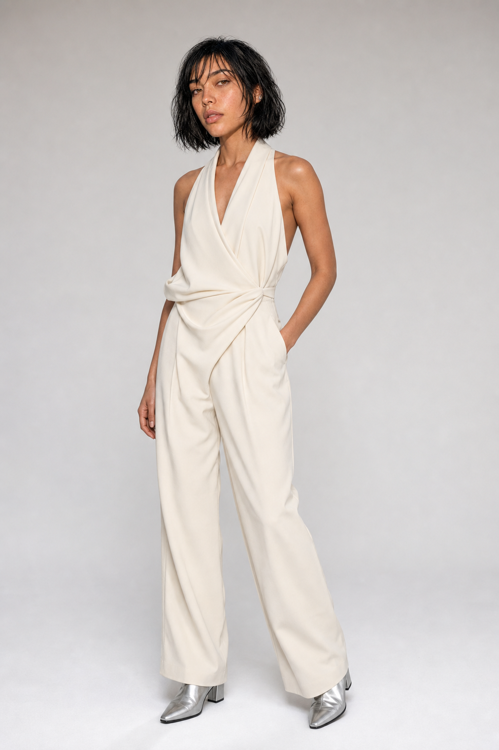 Aria in an ivory sculptural jumpsuit in a studio