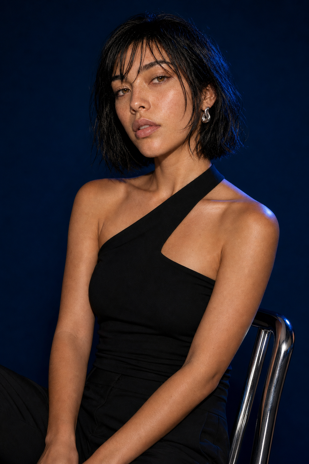 Aria seated in a midnight-blue studio portrait
